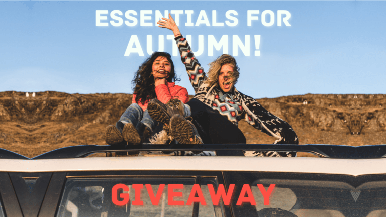 Two ladies sitting on a car during golden hour